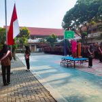 Dessy Prastianti Dewi, S.Pd. sebagai pembina upacara yang mengenakan kebaya pink fanta mencolok di atas panggung.